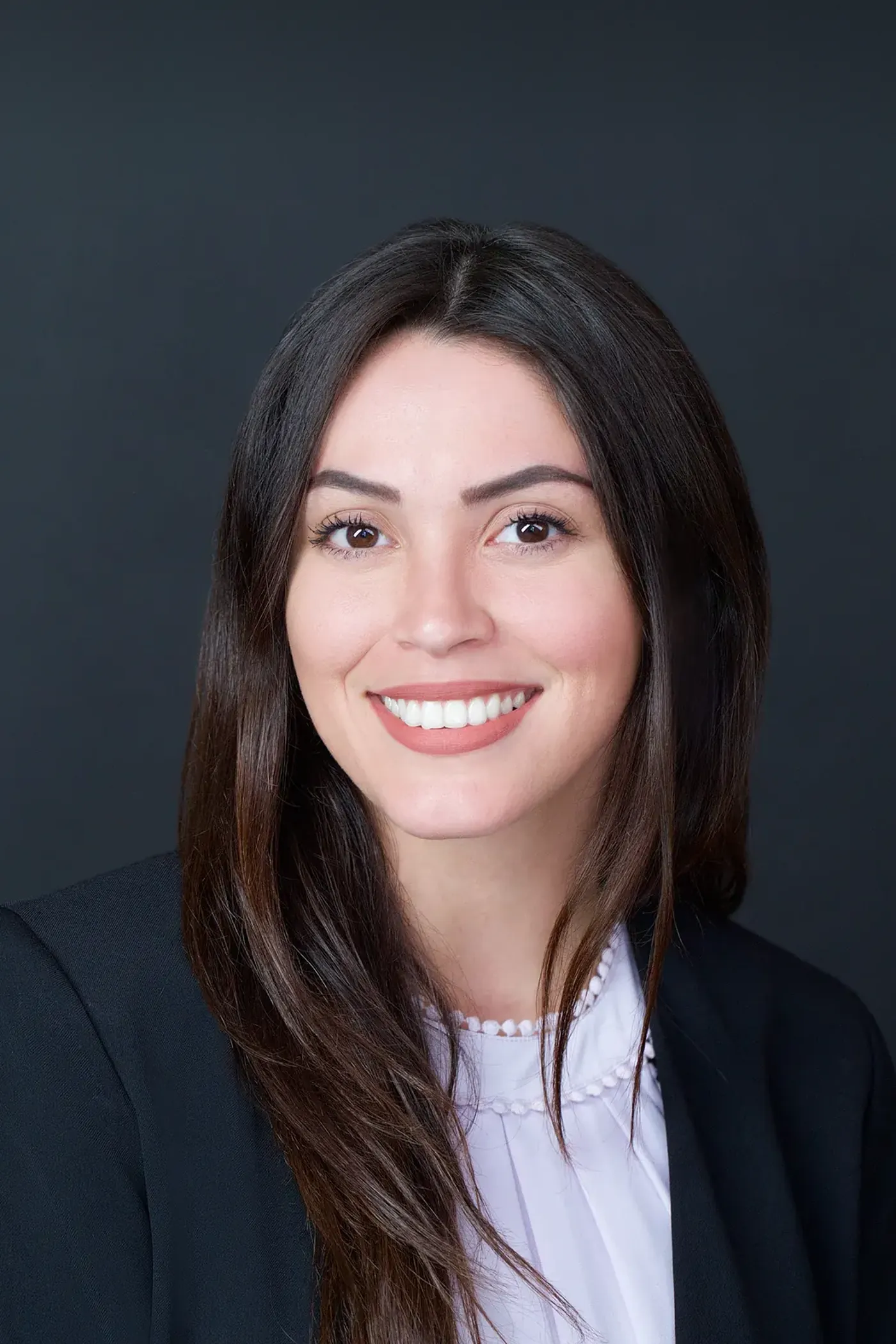 Corporate headshot of a woman with long dark hair in a dark blazer